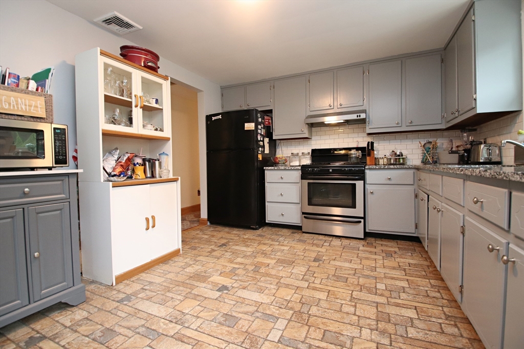 61 Central Street Saugus, MA 01906 - Photo 11 of 42 a kitchen with stainless steel appliances granite countertop a refrigerator stove and sink