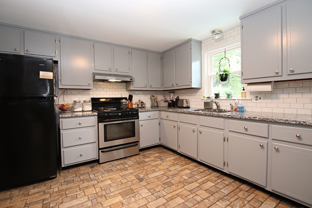 61 Central Street Saugus, MA 01906 - Photo 10 of 42 a kitchen with granite countertop white cabinets and stainless steel appliances