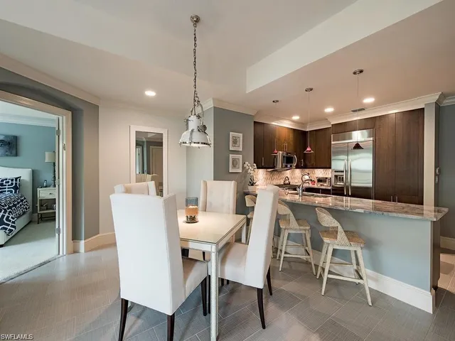 a dining room with a table chairs and a kitchen view