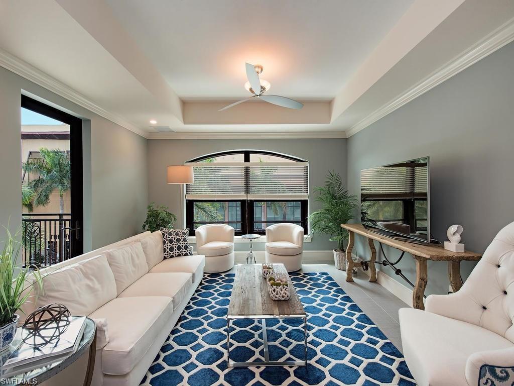 9123 Strada Place, Unit 7306 Naples, FL 34108 - Photo 8 of 19 a living room with furniture a window and a fireplace