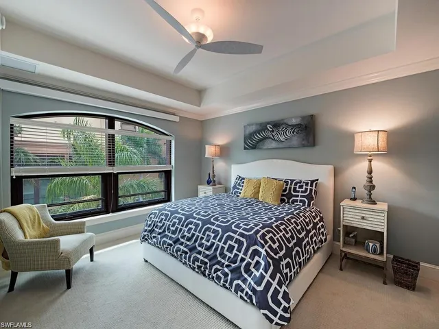 a bedroom with a bed chair and a large window