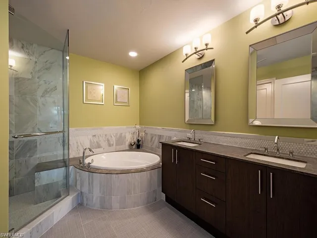 a bathroom with a double vanity sink and mirror with toilet