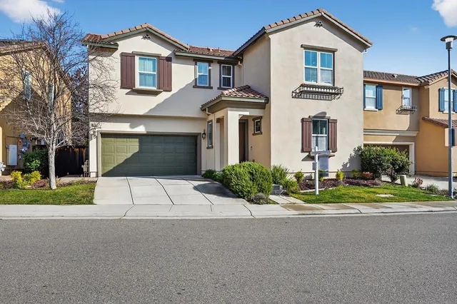 a front view of a house with a yard and a garage