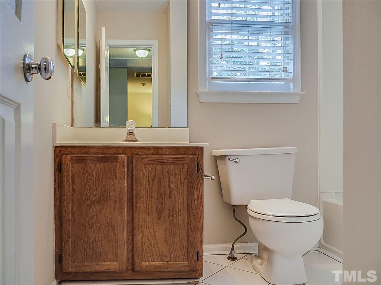 5813 Edgebury Road Raleigh, NC 27613 - Photo 18 of 21 a bathroom with a toilet a sink and a window