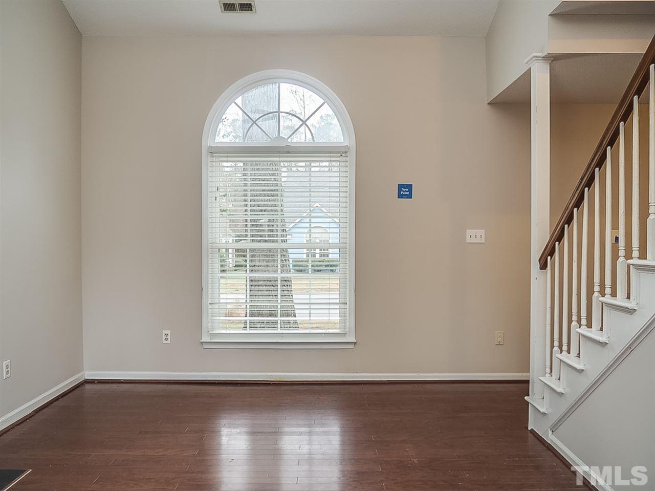 5813 Edgebury Road Raleigh, NC 27613 - Photo 7 of 21 a view of an empty room with wooden floor and a window
