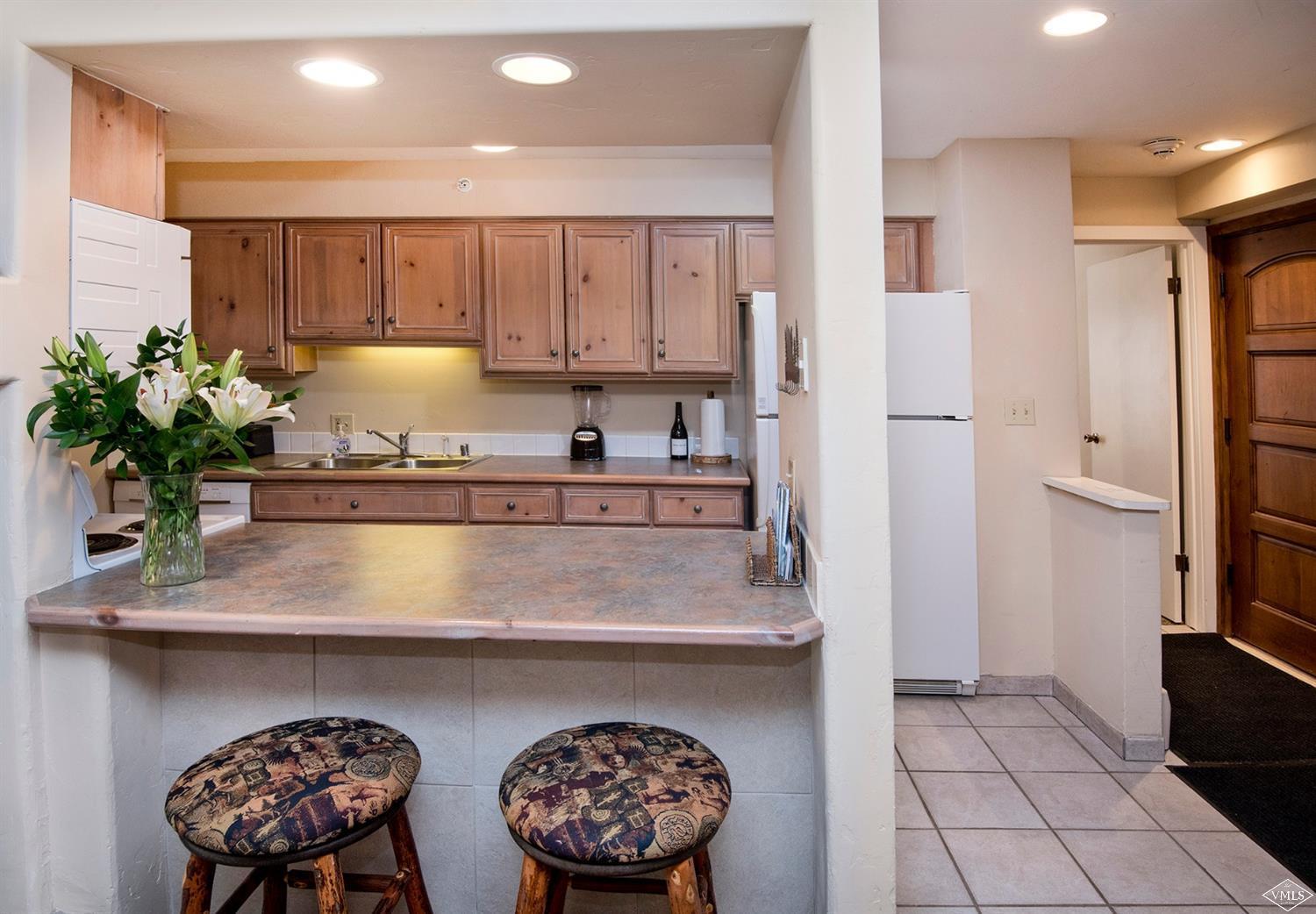 993 Lions Ridge Loop, Unit 325 Vail, CO 81657 - Photo 7 of 19 a kitchen with kitchen island granite countertop a table and a stove
