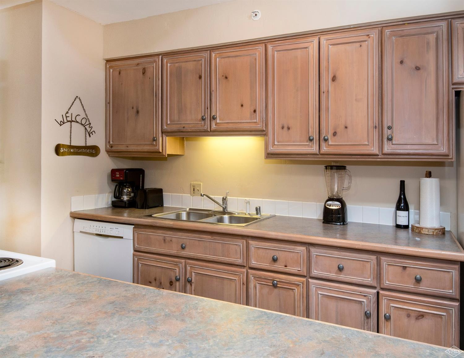 993 Lions Ridge Loop, Unit 325 Vail, CO 81657 - Photo 8 of 19 a kitchen with stainless steel appliances granite countertop a sink dishwasher stove and cabinets