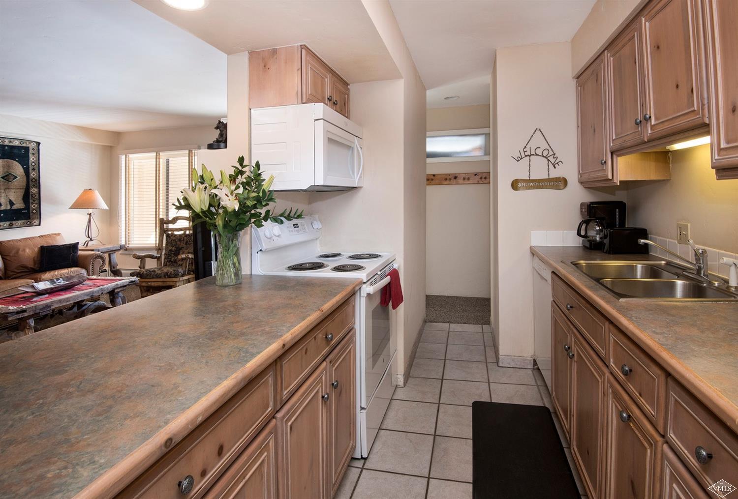 993 Lions Ridge Loop, Unit 325 Vail, CO 81657 - Photo 9 of 19 a kitchen with kitchen island granite countertop a sink a counter space and cabinets
