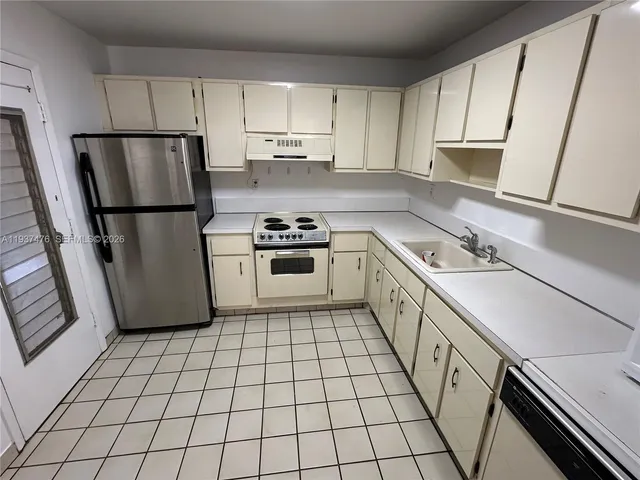 a kitchen with a sink a stove a refrigerator and cabinets