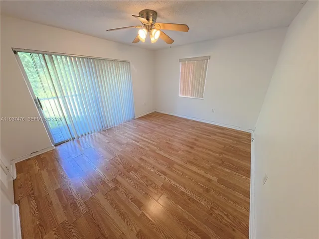 a view of a livingroom with wooden floor and a ceiling fan