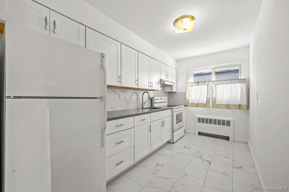40 Firwood Road, Unit MAIN ST Port Washington, NY 11050 - Photo 5 of 18 a kitchen with granite countertop a refrigerator and a sink