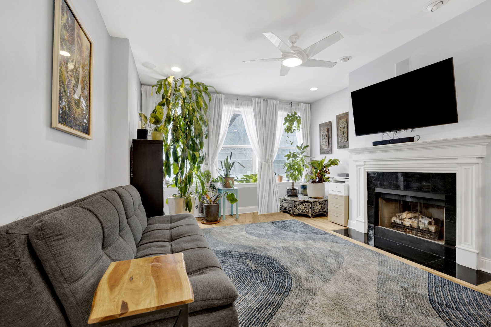 218 South Laflin Street, Unit 101 Chicago, IL 60607 - Photo 3 of 22 a living room with furniture a flat screen tv and a fireplace