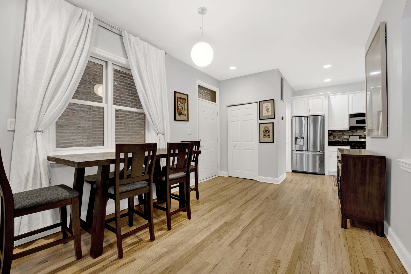 218 South Laflin Street, Unit 101 Chicago, IL 60607 - Photo 5 of 22 a kitchen with stainless steel appliances kitchen island granite countertop a table chairs stove and a kitchen island