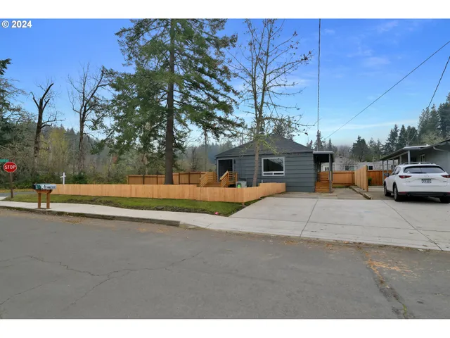 a view of a white house with a yard and sitting area