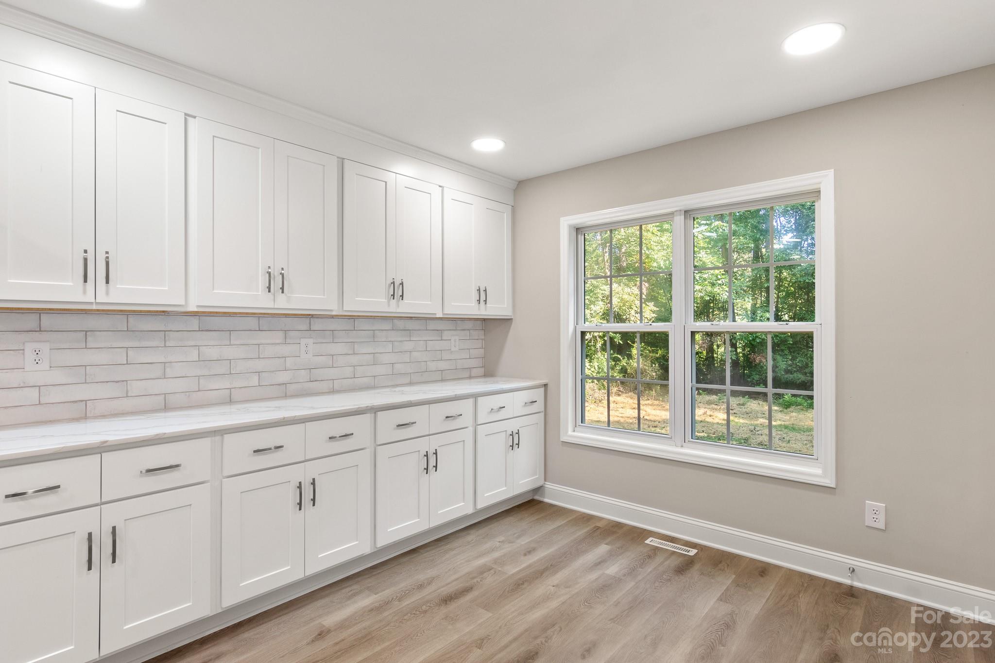 313 Faith Road Mooresville, NC 28115 - Photo 16 of 42 a kitchen with granite countertop white cabinets and a window