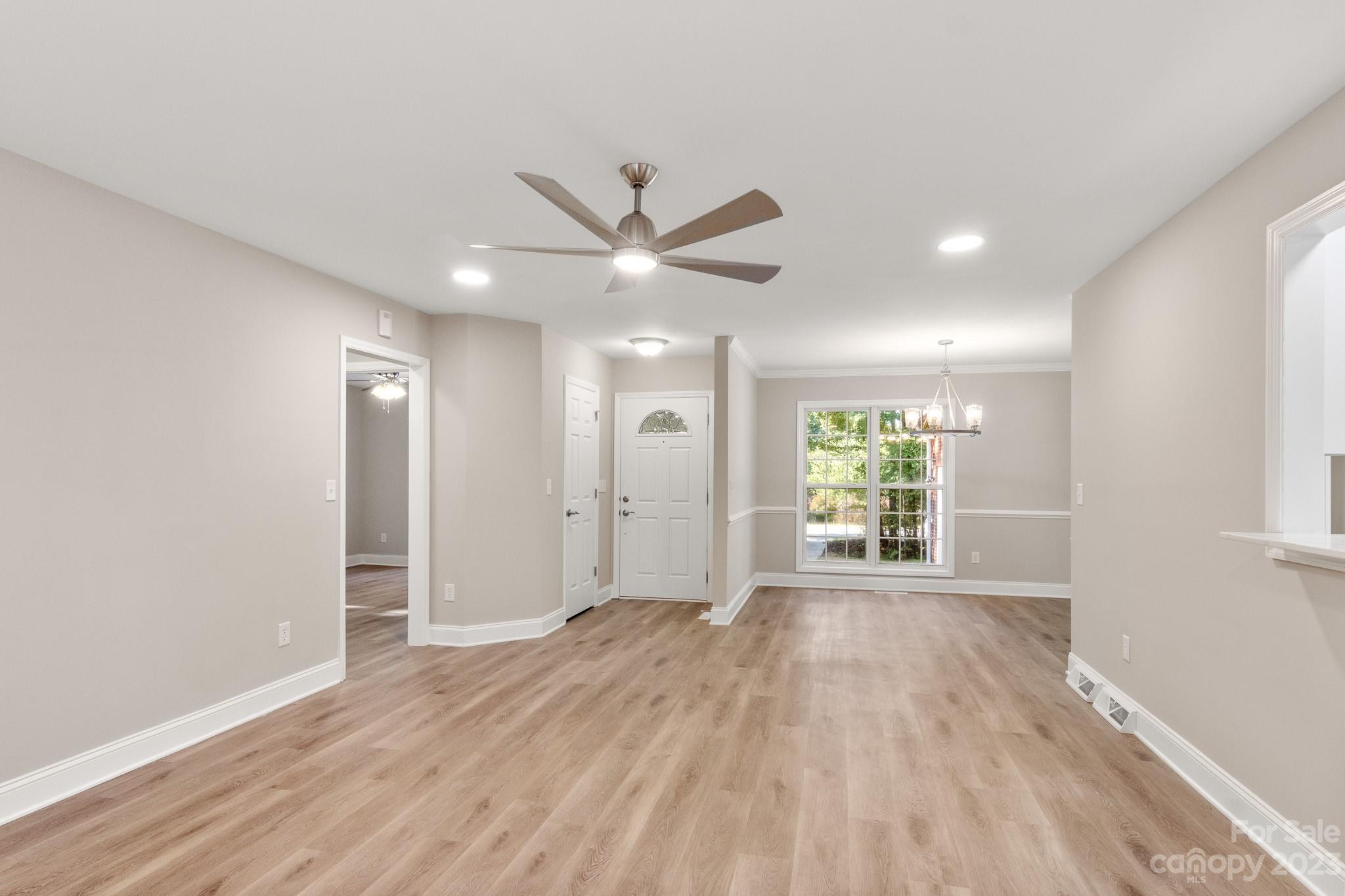 313 Faith Road Mooresville, NC 28115 - Photo 2 of 42 an empty room with wooden floor and a ceiling fan