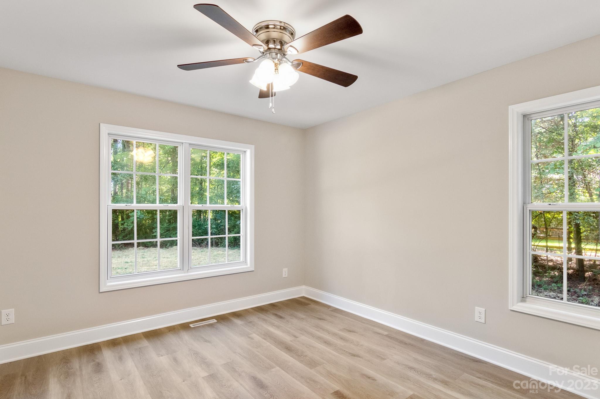 313 Faith Road Mooresville, NC 28115 - Photo 32 of 42 an empty room with wooden floor and windows