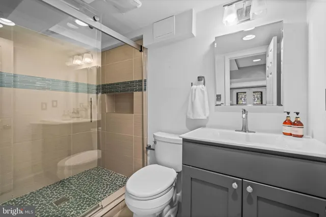 a bathroom with a sink a toilet and shower