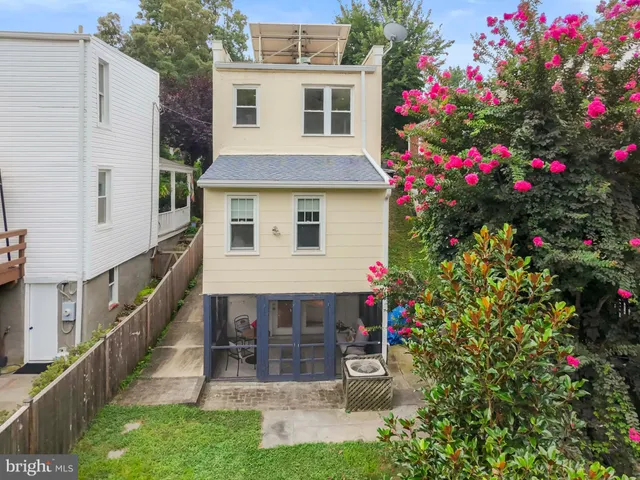 a front view of a house with a yard and potted plants