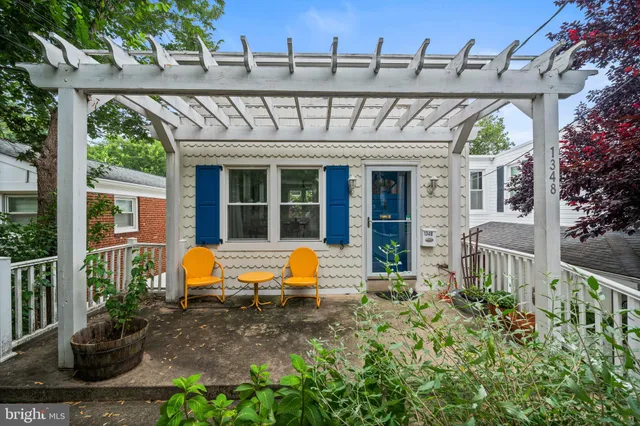 a view of a patio with table and chairs potted plants and large tree