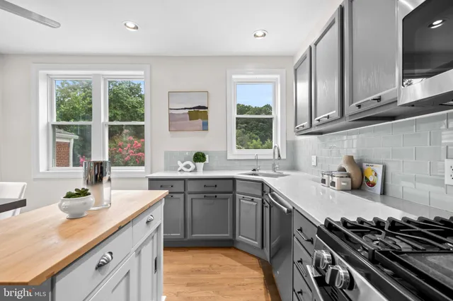 a kitchen with a sink stove top oven and cabinets