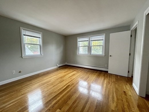 59 Desoto Road, Unit 2 Boston, MA 02132 - Photo 7 of 13 a view of an empty room with wooden floor and a window