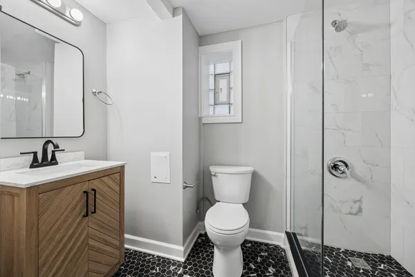 a bathroom with a toilet a sink and shower