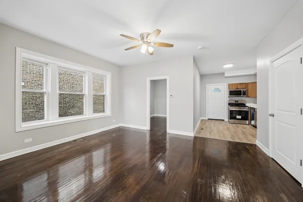 a view of an empty room with window and wooden floor