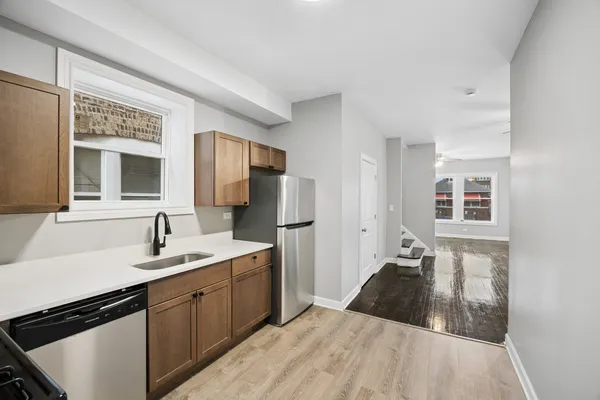 a kitchen with a sink dishwasher a refrigerator and a mirror