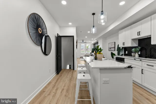 a kitchen with stainless steel appliances granite countertop a sink a stove a refrigerator and island with wooden floor