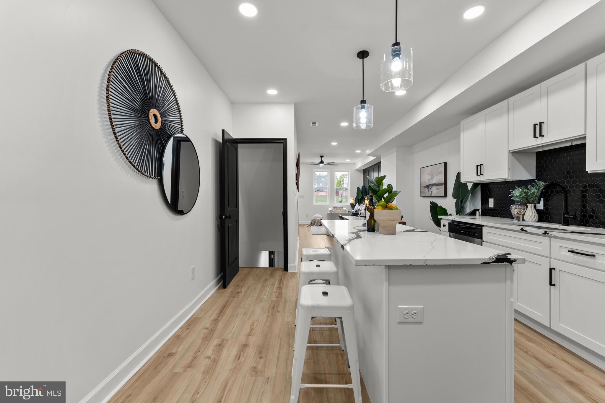 1623 Rutland Avenue Baltimore, MD 21213 - Photo 11 of 38 a kitchen with stainless steel appliances granite countertop a sink a stove a refrigerator and island with wooden floor
