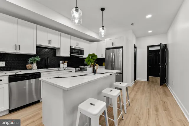 a kitchen with kitchen island a sink stove and refrigerator