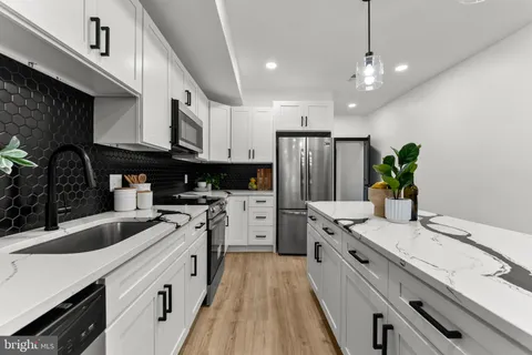 a kitchen with white cabinets and stainless steel appliances