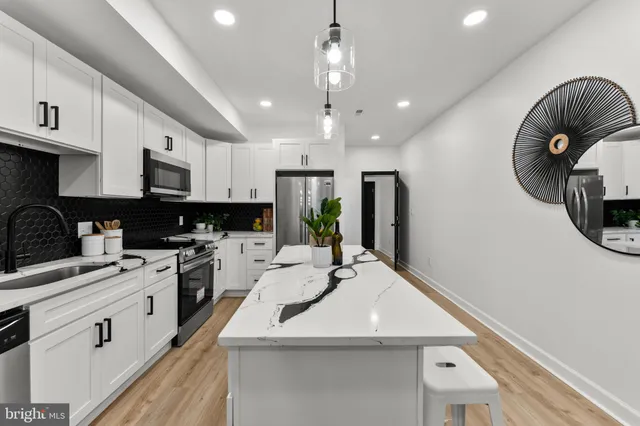 a kitchen with a sink stainless steel appliances and white cabinets