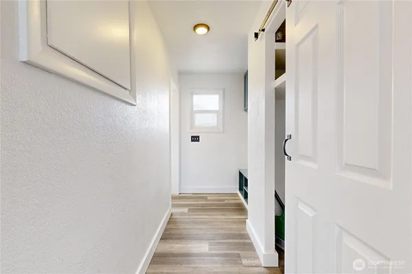 a view of a hallway with wooden floor and staircase