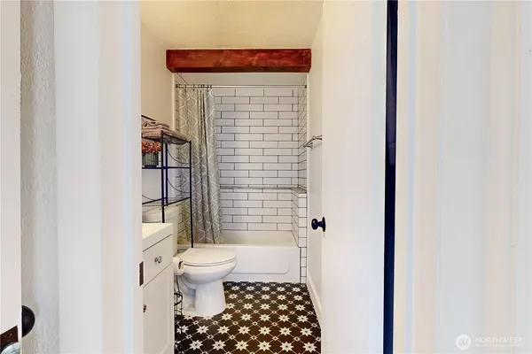 a bathroom with a toilet and a shower curtain
