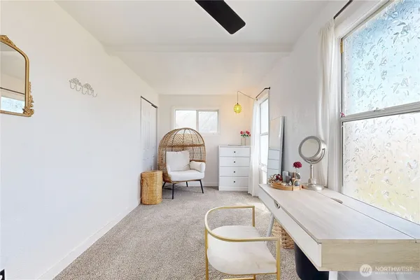 a living room with furniture a window and a potted plant