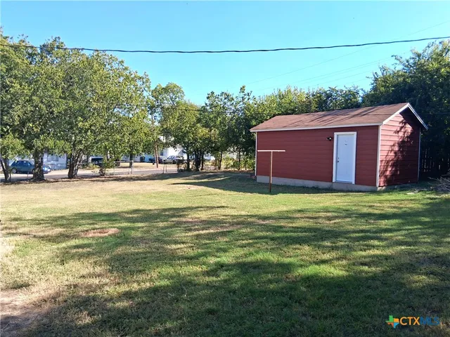 a backyard of a house with lots of green space and outdoor seating