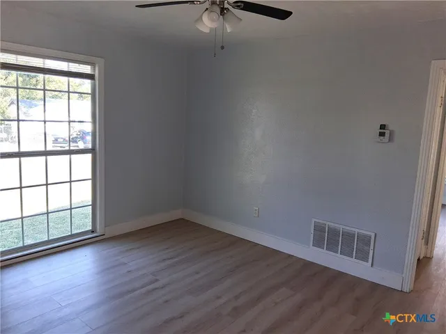 wooden floor in an empty room with a window