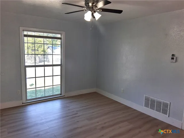 wooden floor in an empty room with a window