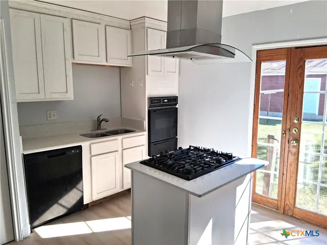 a kitchen with stainless steel appliances a refrigerator and a stove top oven