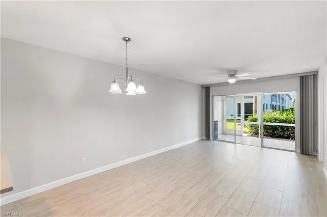 a view of a room with wooden floor fireplace and window