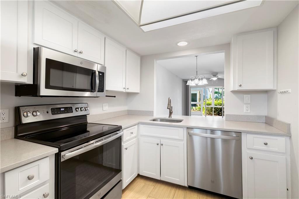 1008 Manatee Road, Unit G103 Naples, FL 34114 - Photo 5 of 24 a kitchen with cabinets stainless steel appliances a sink and a counter space