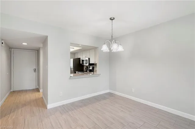 a view of a room with a chandelier fan and wooden floor