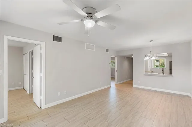 a view of an empty room with window and wooden floor