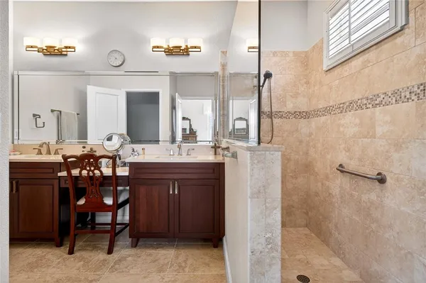 a bathroom with a double vanity sink a mirror and a shower