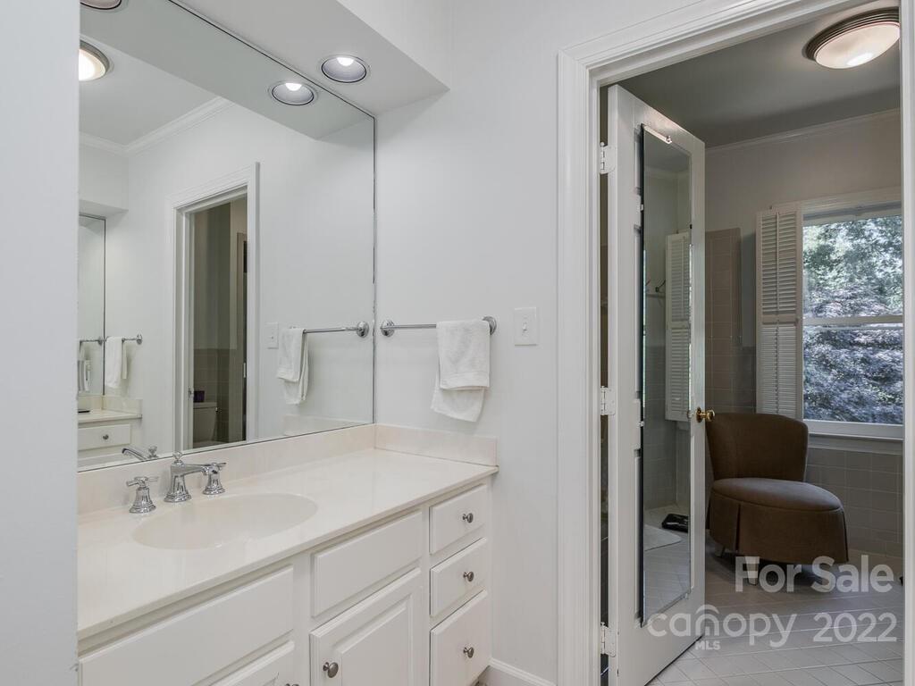 1931 Queens Road Charlotte, NC 28207 - Photo 18 of 23 a bathroom with a granite countertop sink a toilet and a mirror