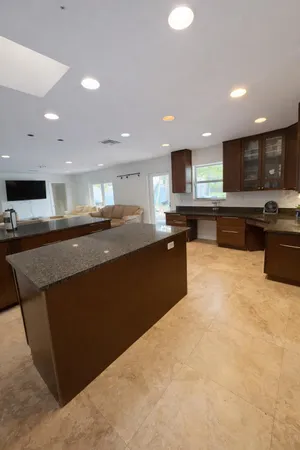 a kitchen with stainless steel appliances granite countertop a refrigerator a sink a stove a microwave a counter top and oven