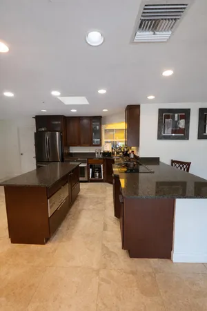 a living room with couches and kitchen view with wooden floor