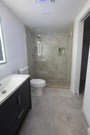 a bathroom with a sink a toilet and shower